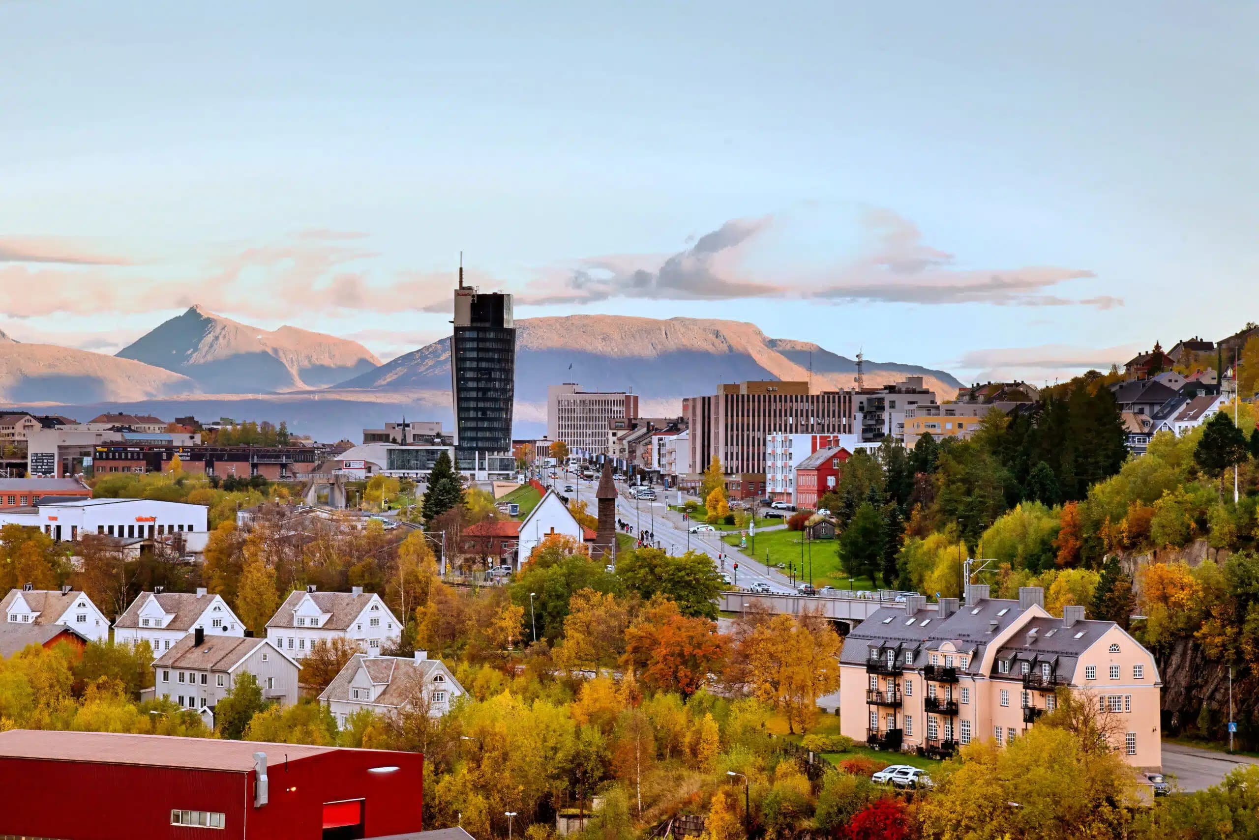 Narvik sentrum i høstfarger med Scandic-hotellet, eldre trevillaer og fjell i bakgrunnen, brukt som illustrasjon i artikkel om beste eiendomsmegler.
